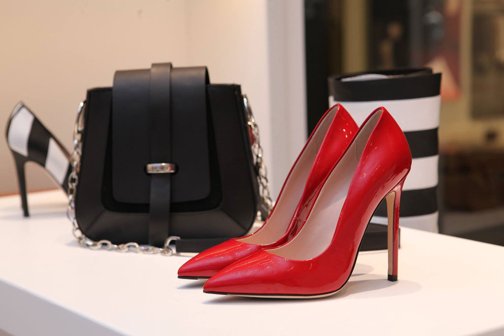 Red women's shoes on sideboard next to bag