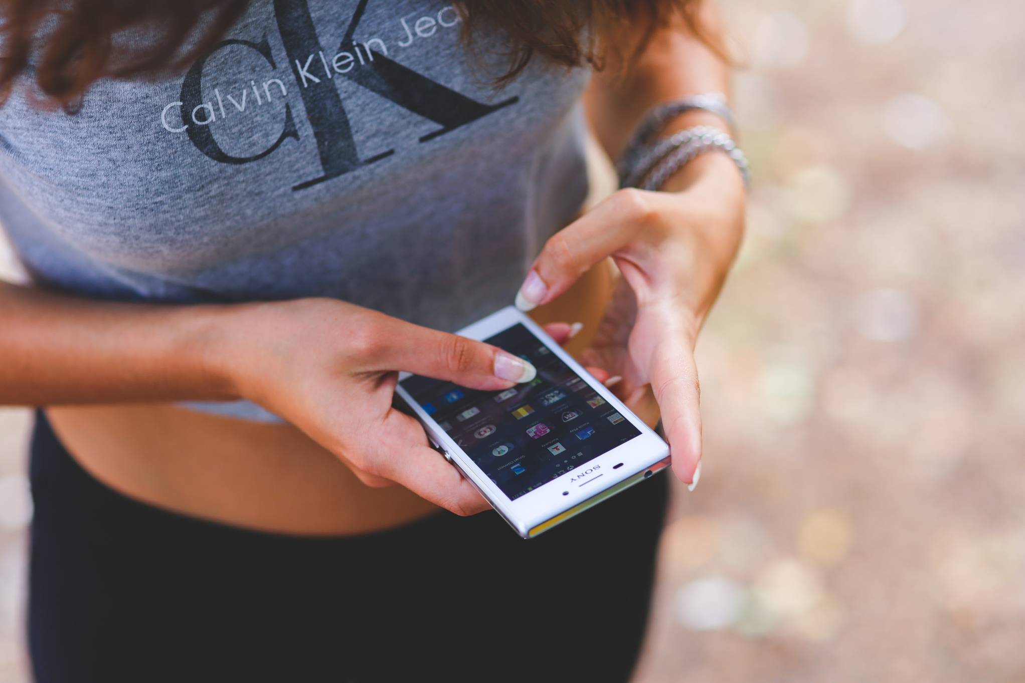 Girl in a t-shirt Calvin Klein for women with a phone